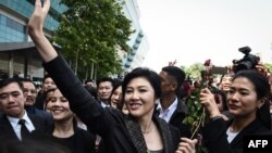 FILE - Former Thai prime minister Yingluck Shinawatra waves to supporters as she leaves the Supreme Court in Bangkok on Aug. 1, 2017. Thailand's Supreme Court on Monday cleared her of corruption in awarding a government contract during her time in office. 
