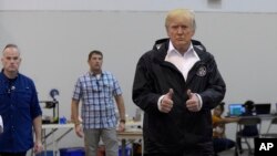 FILE - President Donald Trump gives a thumbs up after meeting people impacted by Hurricane Harvey during a visit to Houston, Texas, Sept. 2, 2017.