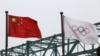 中国国旗和奥运旗帜在北京冬奥组委会外飘扬。（2021年3月30日）