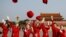 Ushers throw their hats in the air as they pose for photographers at the Tiananmen Square before the start of the closing session of the 19th National Congress of the Communist Party of China, in Beijing, China October 24, 2017.