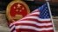 FILE - In this Nov. 9, 2017, file photo, an American flag is flown next to the Chinese national emblem during a welcome ceremony for visiting U.S. China says accusations against an alleged spy of attempting to steal trade secrets from several American avi