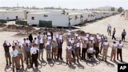 2012年9月11日在一次由伊拉克政府為在巴格達的外交官組織的一次活動中﹐伊朗人民聖戰組織的成員舉著橫幅﹑呼喊口號