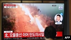 ແມ່​ຍິງ​ຄົນ​ນຶ່ງ​ເບິ່ງ​ຈໍ​ໂທ​ລະ​ພາບ ທີ່​ສະ​ແດງ​ໃຫ້​ເຫັນ​ລາຍ​ງານ​ຂ່າວ​ພ້ອມ​ກັບ​ພາບ​ຂອງ​ການ​ທົດ​ລອງ​ລູກ​ສອນ​ໄຟ ເກົາຫຼີ​ເໜືອ, ຢູ່​ສະ​ຖາ​ນີ​ລົດ​ໄຟ​ໃນ​ນະ​ຄອນຫຼວງ ໂຊ​ລ໌, ເກົາຫຼີ​ໃຕ້, 26 ມິ​ຖຸ​ນາ 2024.