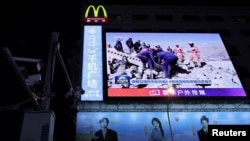 西藏地區日喀則定日縣發生地震後，北京街頭巨大螢幕播放救援人員在搜救行動中的新聞片段。 (路透：2025年1月8日)