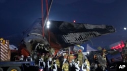 2024年12月29日，救援人員在南韓務安國際機場飛機起火現場抬著一名乘客的遺體。