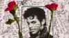 Flowers lay on a T-shirt signed by fans of singer Prince at a makeshift memorial place created outside Apollo Theatre in New York, April 22, 2016.