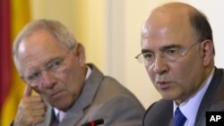 German Finance Minister Wolfgang Schaeuble, left, and his new counterpart from France Pierre Moscovici brief the media after a meeting at the Finance Ministry in Berlin, May 21, 2012.