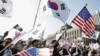 资料照：美韩同盟的支持者在一个集会上挥舞美国和韩国国旗。（2005年10月24日）