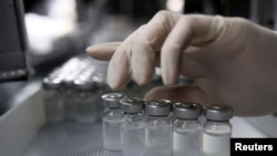 2021 年1 月12 日，一名員工在巴西聖保羅的布坦坦研究所處理裝有科興生物技術公司開發的新冠病毒疫苗。（路透社照片）