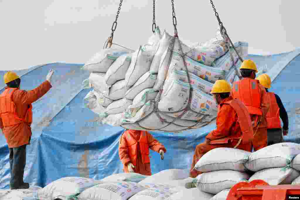 2018年3月22日，中国江苏省南通港口工人装卸进口的大豆产品。 中国4月3日宣布将对包括大豆在内的价值500亿美元的美国商品加征关税，报复川普政府前一日公布的对中国商品增收关税清单。