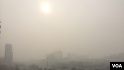 2016 年12月20日13時，霧霾掩映下的北京東長安街建國門立交橋 （美國之音葉兵拍攝）