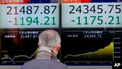 一名男子在东京观看电子屏幕显示的股市信息。（2018年2月6日）