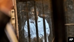 被罷免的埃及總統穆爾西在2014年1月18日的庭審中站在玻璃籠裡(資料照片)