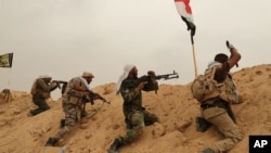 什葉派民兵巴德爾旅成員同“伊斯蘭國”激進分子在安巴爾省費盧傑郊外前線作戰。（2015年6月1日）