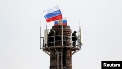 乌克兰海军司令部附近俄罗斯国旗飘扬，被认为是俄罗斯军人的武装分子在烟筒顶部站岗
