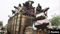 People load on onto a truck carrying residents fleeing south from an Islamic insurgency in northern Mali at the trading town of Mopti, June 19, 2012.