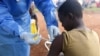 FILE - A Congolese health worker administers Ebola vaccine to a boy who had contact with an Ebola sufferer in the village of Mangina in North Kivu province of the Democratic Republic of the Congo, Aug. 18, 2018.