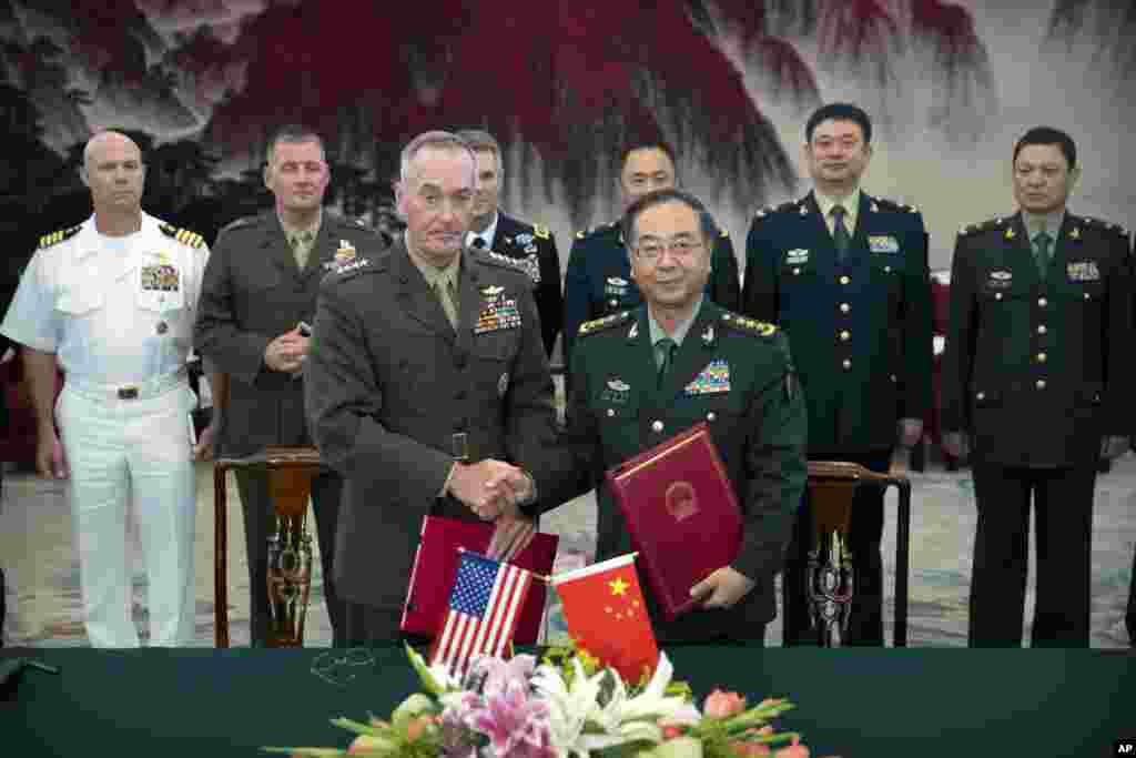 美军参联会主席邓福德上将（前左）与中国中央军委联合参谋部参谋长房峰辉在北京签署协议后握手 （2017年8月15日）。邓福德曾说， 两国之间&ldquo;有很多棘手的问题&rdquo;需要解决。