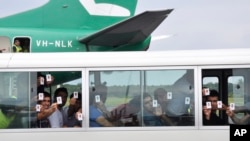 一些寻求庇护的难民高举他们的身份证。（资料图）