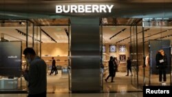 ​ຜູ້​ຊາຍ​ຄົນ​ນຶ່ງ​ຍ່າງ​ຜ່ານ​ນ້ານ Burberry ໃນ​ນະ​ຄອນຫຼວງ ປັກ​ກິ່ງ, ຈີນ.