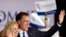 Republican presidential candidate Mitt Romney, right, and his wife Ann wave to a crowd in Schaumburg, Illinois, after Romney won the Illinois Republican presidential primary, March 20, 2012.