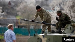 在乌克兰东部，乌克兰士兵站在坦克上与亲俄抗议者交谈（2014年4月16日）