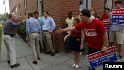 U.S. Senator Lamar Alexander (L) (R-TN) waves as his supporters and supporters of his competitor State Rep. Joe Carr looks on, as he campaigns in Dickson, Tennessee Aug. 3, 2014.