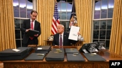 Президент США Дональд Трамп подписывает исполнительные распоряжения в Овальном кабинете Белого дома в Вашингтоне, 20 января 2025 года. (Фото: Jim WATSON / POOL / AFP)