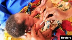 A health worker administers immunization to a displaced child at Nyakabande refugee transit camp in Kisoro town, 521 kilometers southwest of Uganda's capital Kampala, July 13, 2012.