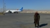 一名塔利班成员站在喀布尔机场的跑道上。(2021年12月8日)