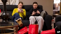 芝加哥的一对夫妇在11月29日黑色星期五购物周末在梅西百货商店购物时小憩片刻。