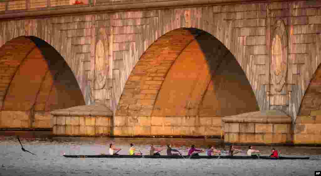 一支划船队清晨练习时经过华盛顿波托马克河上的纪念大桥。 