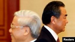 2013年8月5日中国外交部部长王毅(右)和越南共产党总书记阮富仲在河内擦肩而过