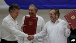 Shugaban Colombia Manuel Santos daga hagu, madugun 'yan tawaye Timoleon Jimenez da dama sai kuma shugaban kasar Cuba Raul Castro a tsakiya