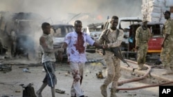 索馬里首都摩加迪沙發生爆炸，圖為一名軍人攙扶一名受傷的平民 （2017年10月14日）