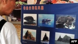 一名男子2010年9月11日在台北縣中和市釣魚島爭端會議期間觀看中國所稱的釣魚島和日本所稱的尖閣島的圖片