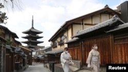 日本京都兩名戴著口罩的婦女走過空蕩蕩的街頭。（2021年月13日）