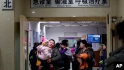 家长和孩子在北京儿童医院的候诊室等候。（2016年12月18日）