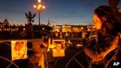 在圣彼得堡的广场上，俄罗斯妇女面对空难死者的照片（2015年11月3日）