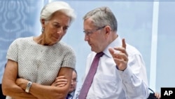 國際貨幣基總裁拉加德(左)正與歐洲金融穩定基金主席克勞斯雷格林(右)在歐盟部長會議上進行交談(2015年7月11日)。