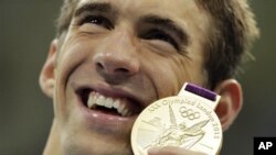 菲尔普斯7月31日在伦敦奥运会上手持他在4x200米自由泳接力中赢得的金牌