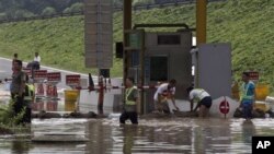 7月23日救災人員在北京房山區一個公路收費站外堆沙包