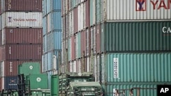 圖為中國上海一個港口附近的卡車正在搬運集裝箱。(資料照)