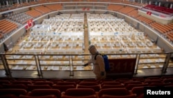 一名身穿防護服的工人正在給一個由體育館改建的方艙醫院消毒，為關艙做準備。（2020年3月8日）